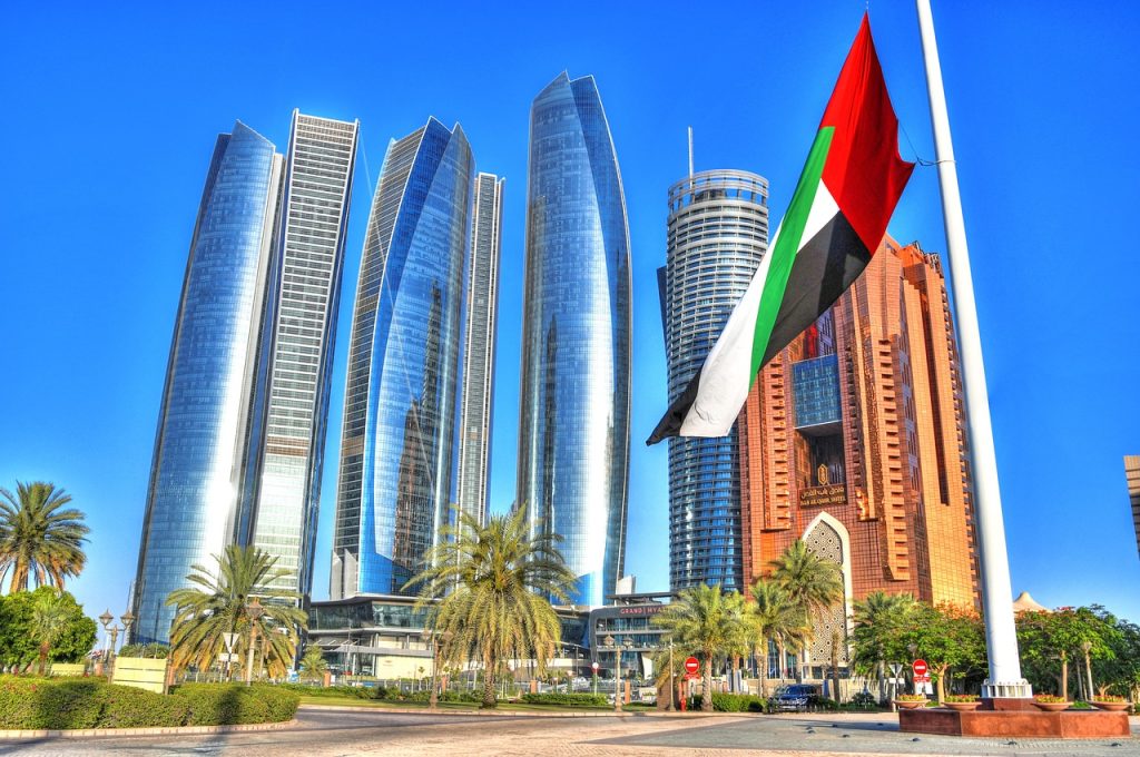 Imagen de rascacielos en Abu Dhabi con la bandera izada.