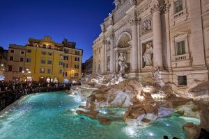 Vista nocturna de la Fontana de Trevi de Roma iluminada.